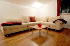 Die große Wohnzimmer-Couch, die durch Verschieben des linken Elements zum Doppelbett wird